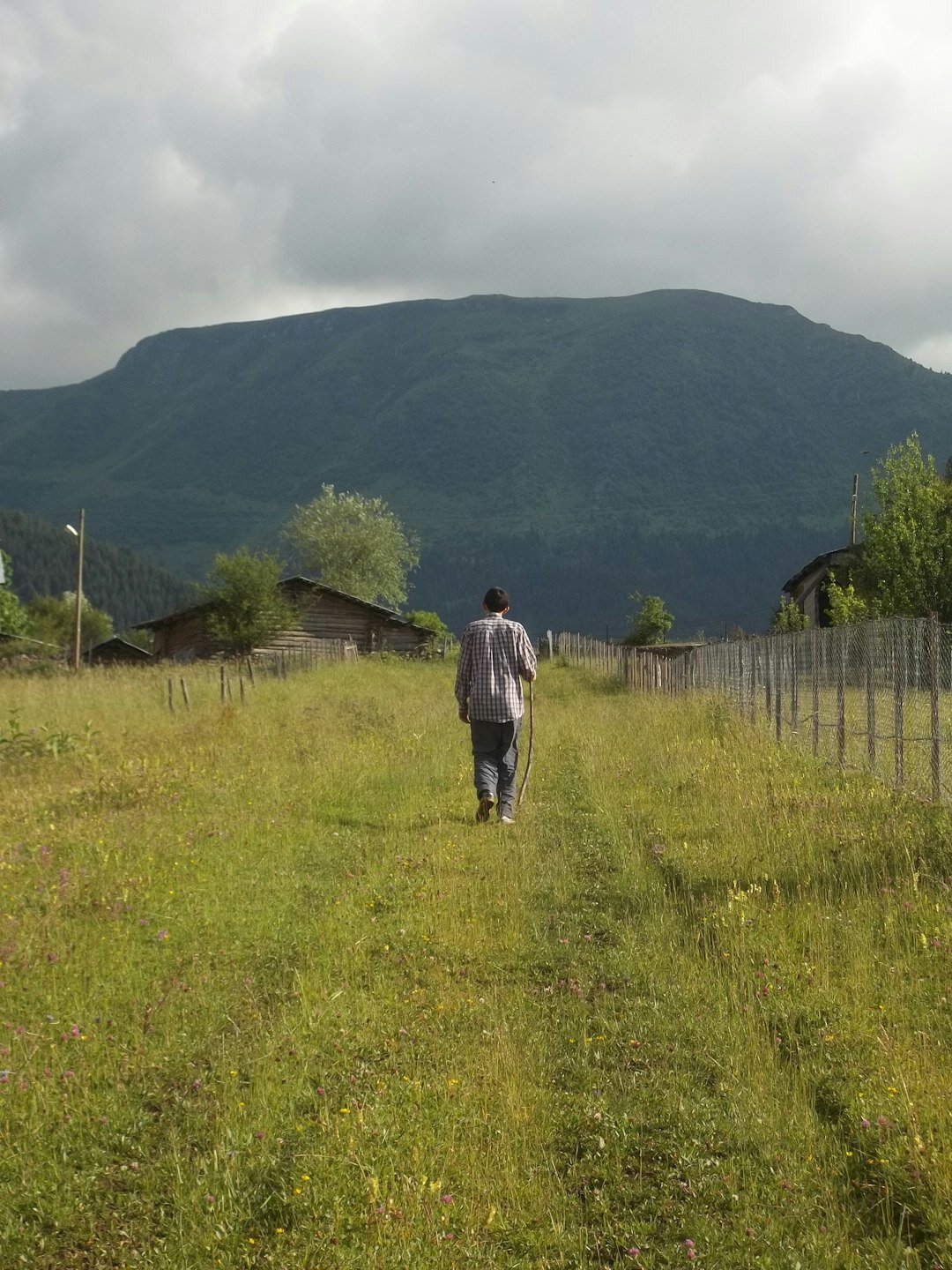 Starija osoba čita novine za stolom uz kavu
